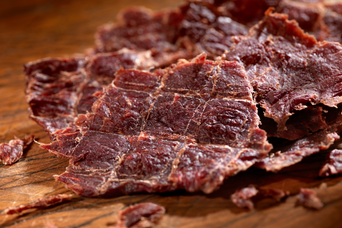 Beef jerky on a brown surface.