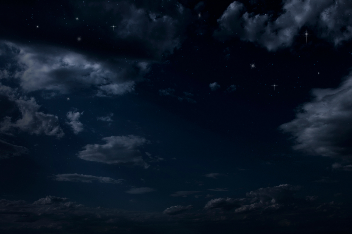 A dark sky with clouds and stars.