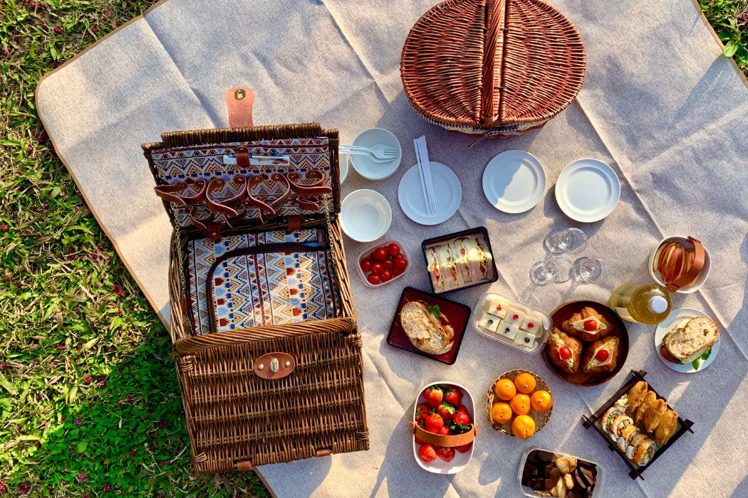 Picnic spread with picnic basket and foods.