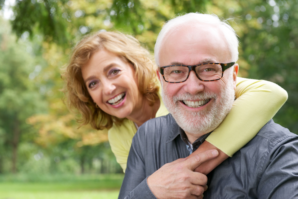 Older couple smiling at the camera.