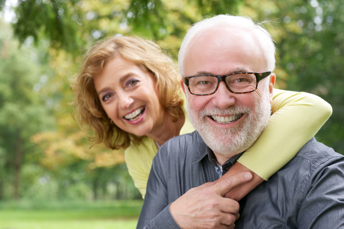 Older couple smiling at the camera.