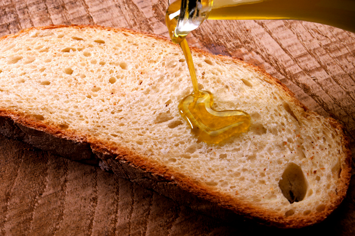 Drizzling olive oil on bread.