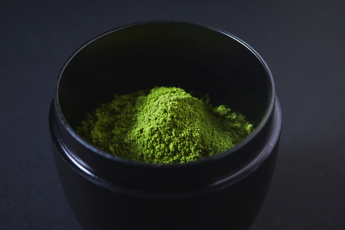 Matcha powder on a black bowl.