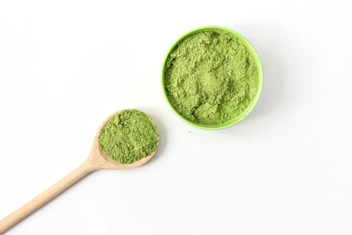 Matcha powder on spoon and bowl.