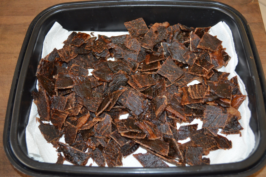 Homemade beef jerky pieces spread across a paper towel-lined tray, showing the finished result of dehydrating beef jerky.