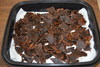 Homemade beef jerky pieces spread across a paper towel-lined tray, showing the finished result of dehydrating beef jerky.