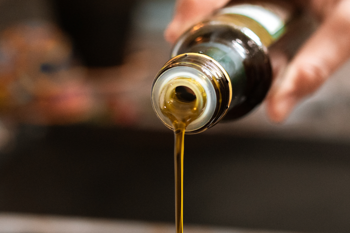 Olive oil being poured from a bottle.