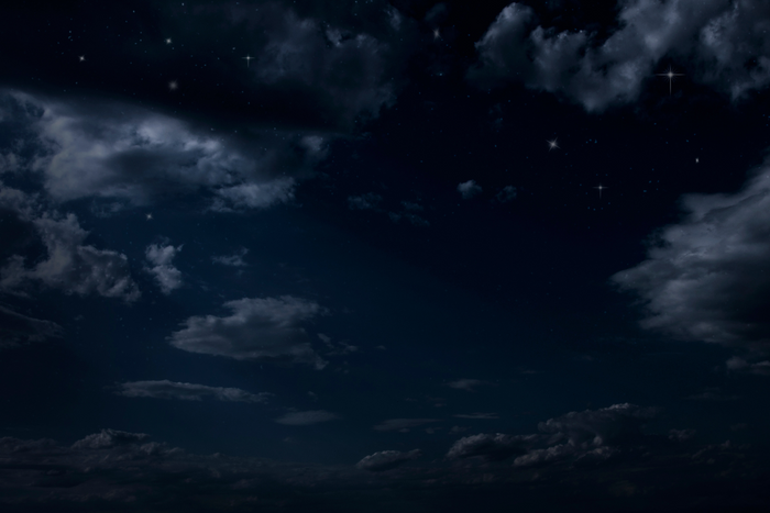 A dark sky with clouds and stars.