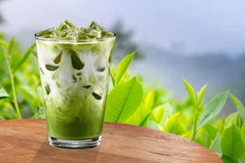 Iced matcha latte with fresh tea leaves.