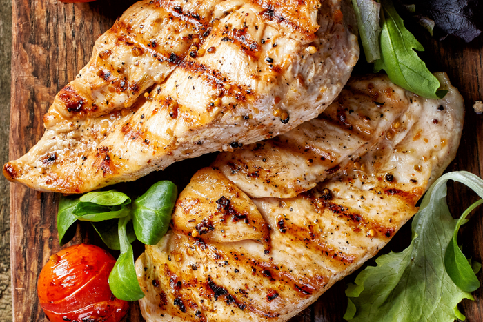 Grilled chicken with leafy greens and spices.