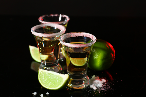 Several green tea shots with lime in a row.