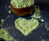 Matcha green tea powder in a heart shape symbolizing how much matcha per day supports heart health