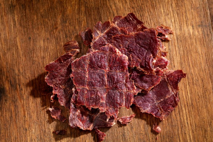 Thin slices of beef jerky on a wooden surface, ideal for low-carb diabetic diets.