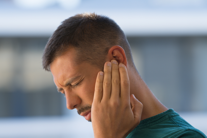 Man experiencing tinnitus.