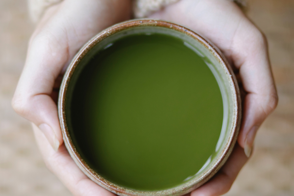 Hands holding a matcha tea.