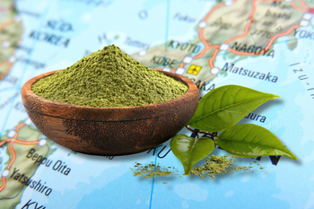 Matcha powder and tea leaves on a map of Japan representing different Japanese matcha cultivars.