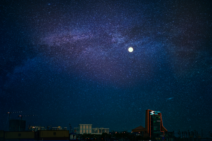 Night sky with moon in shining in the distance.