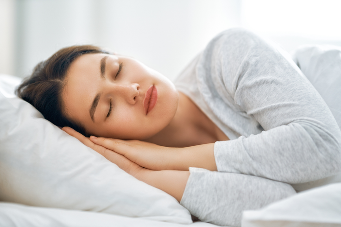 Person sleeping peacefully on a bed, representing rest, relaxation, and the long-term effects of melatonin on sleep quality and emotional wellness.