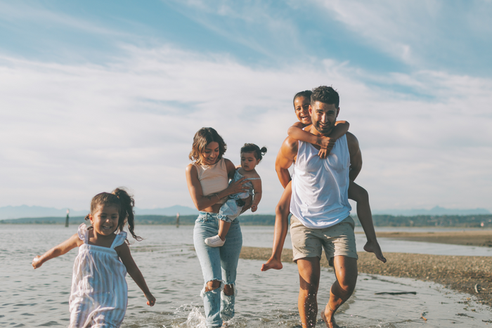 Parents walking with their children at the beach.