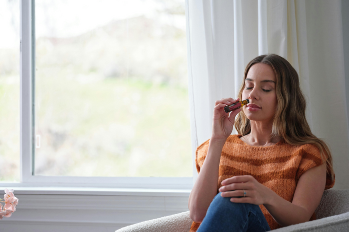 Woman smelling essential oil.