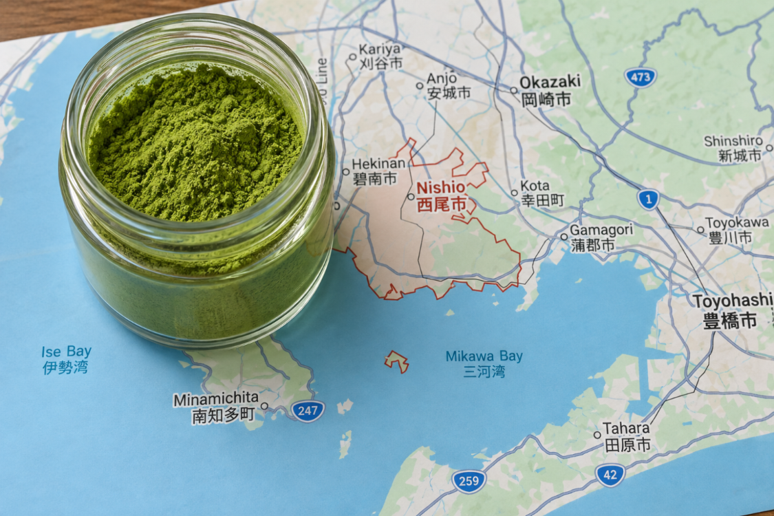 Jar of green Nishio matcha powder on a map of Aichi Prefecture, Japan.