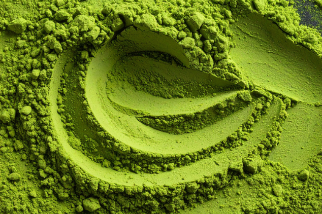 A close-up shot of finely ground matcha powder forming swirling patterns and textures.