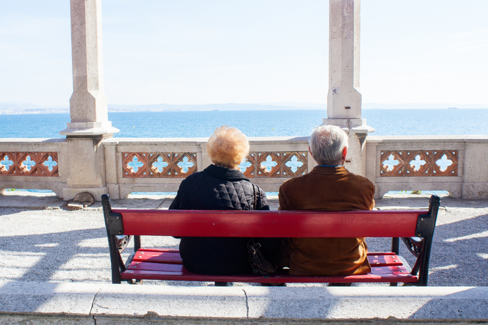 Elderly couple sitting on a bench.
