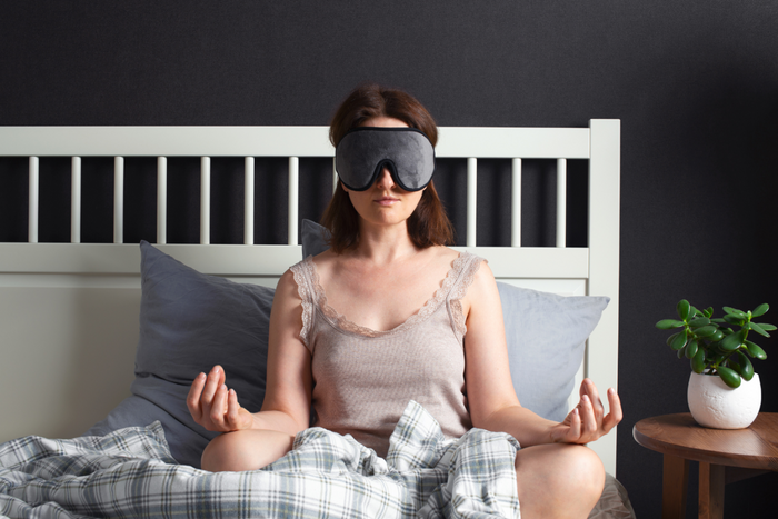 Woman meditating at bed.