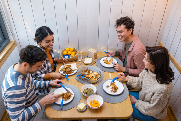 Group of friends smiling and sharing a meal.