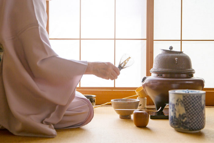 Woman sitting on the floor during a tea ceremony.
