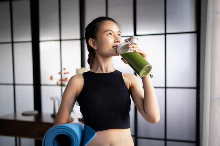 Fit woman drinking matcha after workout, showing matcha as a clean pre- or post-fast drink.